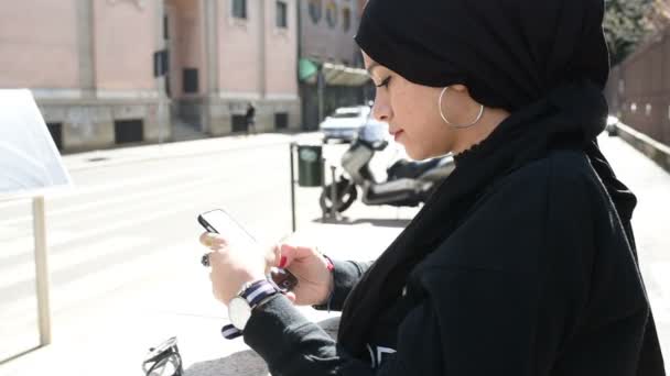 Young Caucasian Woman Wearing Hijab Outdoor Using Smartphone Surfing Web — Stock Video