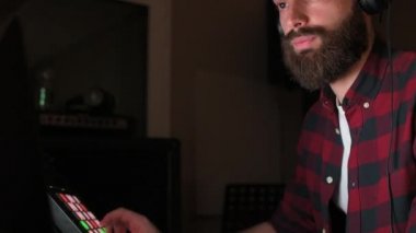 Genç adam DJ 'i mpc pad karıştırma stüdyosunu kullanıyor - ses yapımcısı, klavye denetleyici, karıştırma konsepti