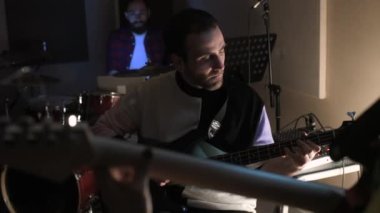 Elektronik bas çalan genç müzisyen - Müzik grubu bir kayıt stüdyosunda sahne alıyor - beste, müzik, prova konsepti