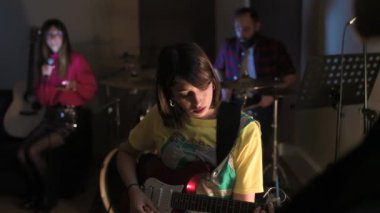 Elektronik bas çalan genç bayan müzisyen - Müzik grubu bir kayıt stüdyosunda sahne alıyor - beste, müzik, prova konsepti