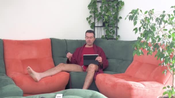 Single Mann Hause Entspannt Auf Sofa Smartphone Und Tablet Internet — Stockvideo