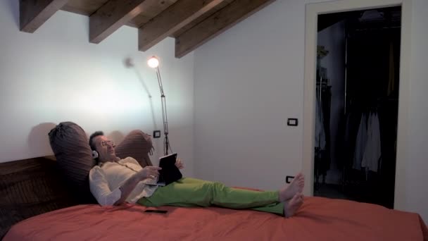 Volwassen Man Binnen Huis Liggend Bed Met Behulp Van Tablet — Stockvideo