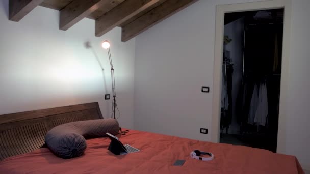 大人の男は服のベッドルームを折り畳み タブレットを使用して映画のストリーミングを見て横にベッド エンターテイメント テクノロジーの概念 — ストック動画