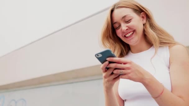 スマートフォンを使って屋外の若い女性ウェブ取引暗号通貨笑い — ストック動画