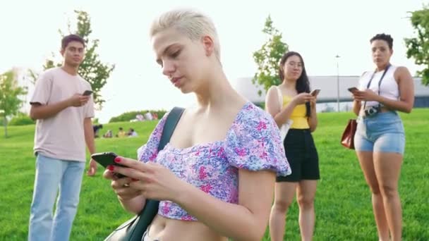 在户外使用智能手机的年轻女性手牵着微笑聊天 分享或上网 — 图库视频影像