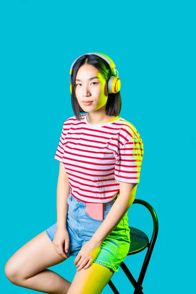 Junge Asiatin Trägt Drahtlose Kopfhörer Und Hört Musik Ernst Und — Stockfoto