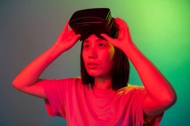 3 boyutlu gözlük teknolojisi kullanan genç Asyalı kadın web 3 metaevreninin tadını çıkarıyor.