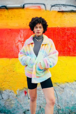 Genç siyah stil kıvırcık kıvırcık saçlı kadın. Açık havada havalı tavır ve kendine güvenen.