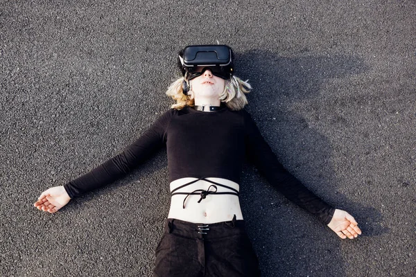 Mladá Nekonformní Žena Ležící Venku Použití Rozšířené Reality Sluchátka Cyberpunk — Stock fotografie