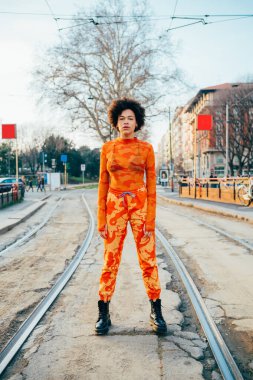 Havalı, kıvırcık saçlı, kendine güvenen, havalı bir kadın.