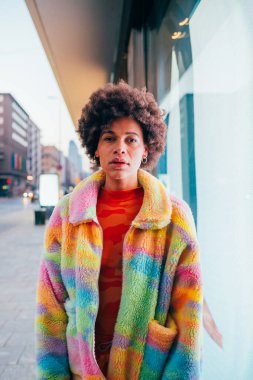 Genç siyah stil çağdaş siyah kadın gece dışarıda kameraya kendinden emin bakıyor.