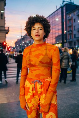 Havalı tavır genç siyahi kadın kamera önünde ciddi poz veriyor.