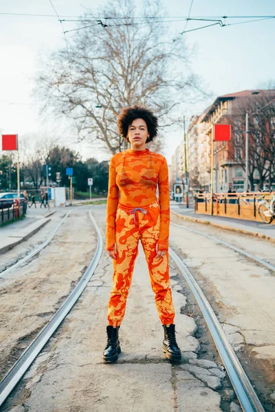 Havalı, kıvırcık saçlı, kendine güvenen, havalı bir kadın.