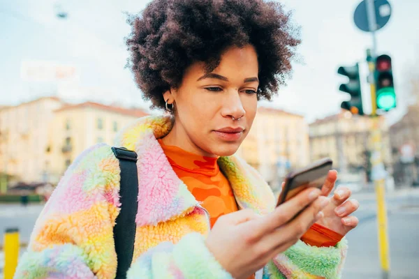 年轻的黑人妇女使用智能手机上网 在网上交易比特币 — 图库照片