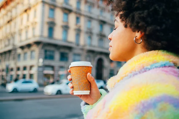 若いです黒の女性屋外飲料コーヒー耐久性のあるカップ歩く街 — ストック写真