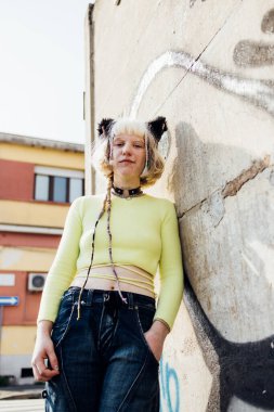 Gülümseyen çift cinsiyetli olmayan sıvı. Makyajsız kadın dışarıda poz veriyor. Kamera karşısında gülümsüyor.