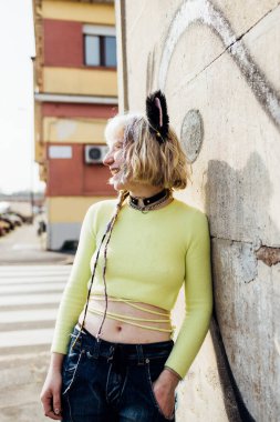 İkili olmayan genç bir kadın. Makyaj yapmak yok. Gülüyormuş gibi yapmak yok. 