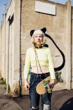 Gender fluid queer diverse woman skater real beauty posing outdoor looking camera serious and confident