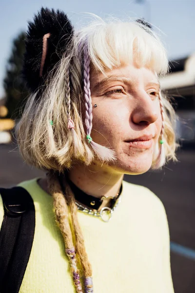 Gender fluid no make up young woman outdoor looking over serious and confident