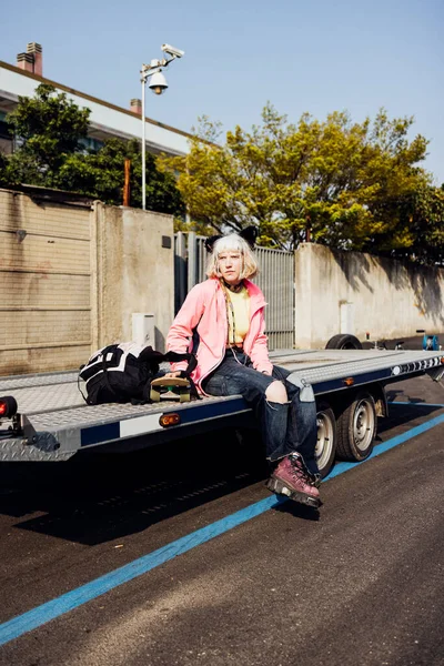 Real beauty body positive woman student posing outdoor with skateboard and backpack