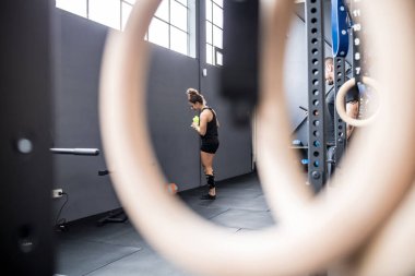 Young woman taking break training resting drinking water reusable bottle