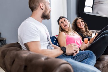 Friends sitting indoors together having fun laughing drinking coffee 