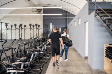 Two sportive man indoors gym with duffel bag  walking locker room preparing for training