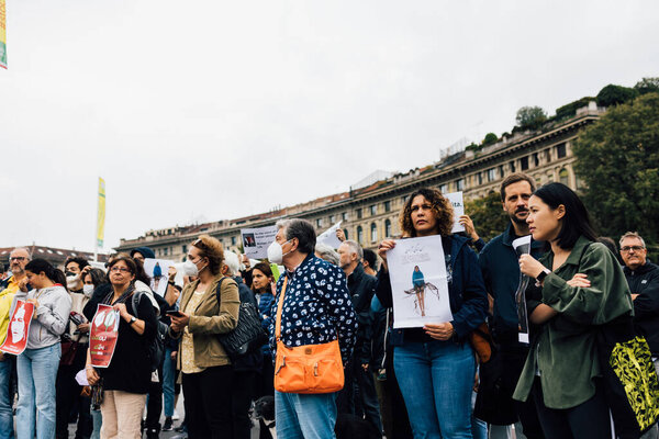 MILAN, ITALY - SEPTEMBER 25, 2022: Protestors demonstrating showing protest sign at Castello Sforzesco, following the death of Mahsa Amini. 