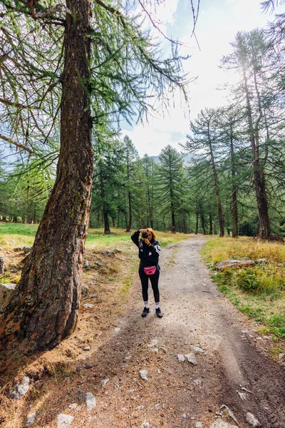 Young woman photographer taking picture in amazing countryside