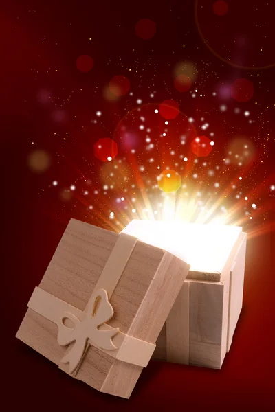 Opened gift box that emits a warm and bright light — Stock Photo, Image