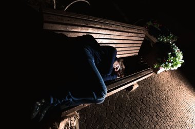 Homeless girl on the bench clipart