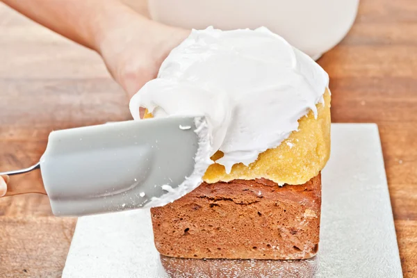 Spreading cream with spatula — Stock Photo, Image