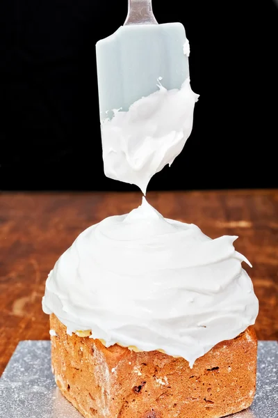 Spreading cream on cake icing — Stock Photo, Image