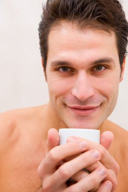 elinde fincan gülümseyen genç adam