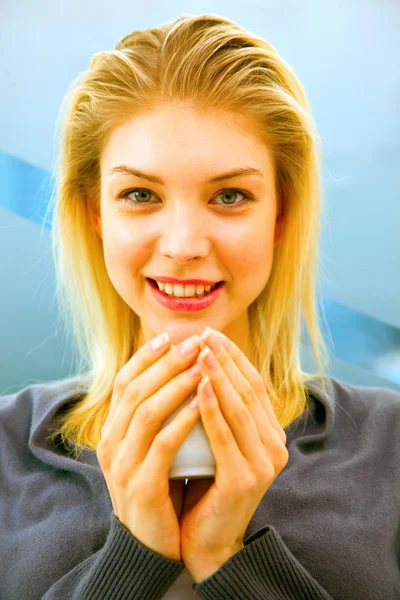 Μεγέθυνση της χαμογελώντας νεαρή γυναίκα εκμετάλλευση Κύπελλο — Φωτογραφία Αρχείου