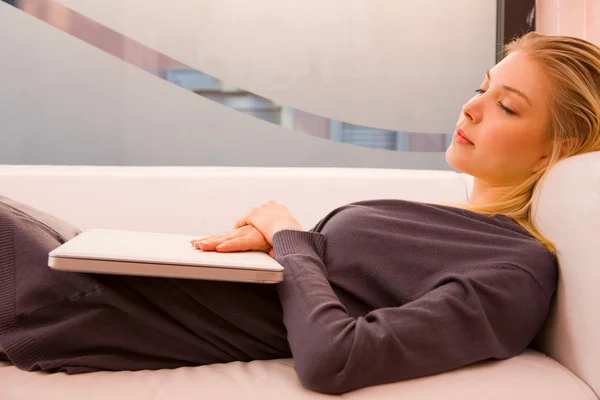 Молодая женщина с ноутбуком спит диван — стоковое фото