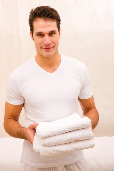 Young man holding stack of fresh towels — Stock Photo, Image