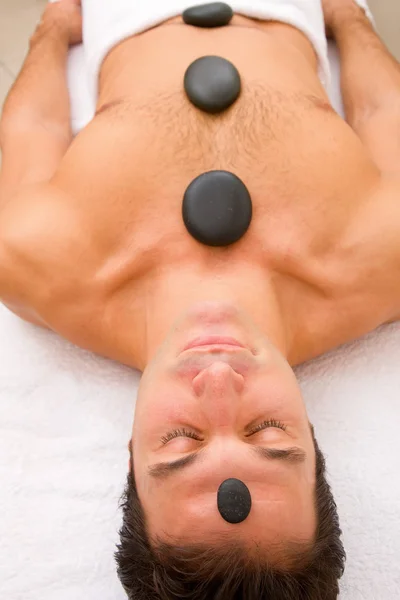 Hombre recibiendo un masaje con piedras calientes — Foto de Stock