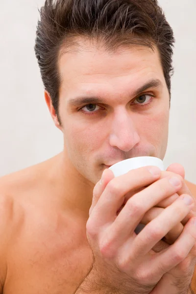Man in spa cup in de buurt van mond houden — Stockfoto