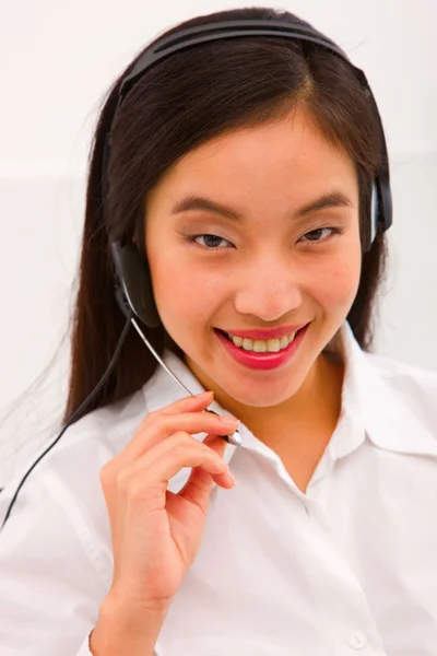 Närbild av en leende ung kvinna med headset — Stockfoto