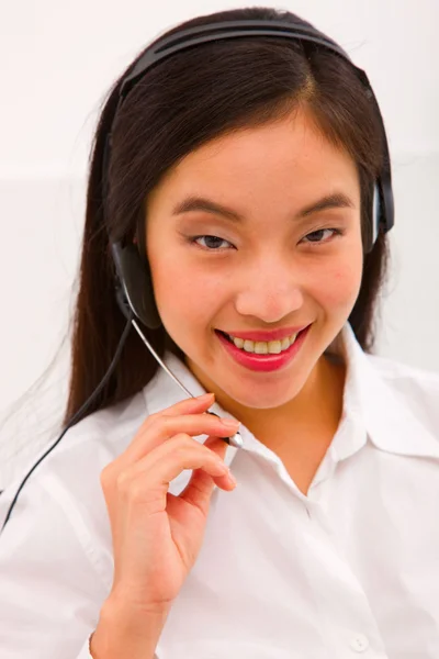 Primo piano di una giovane donna sorridente con auricolare — Foto Stock