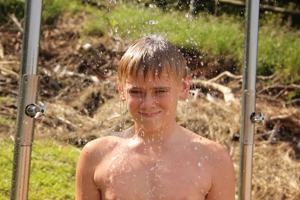Se usmívám chlapec osprchování na pláži — Stock fotografie
