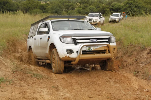 White Ford Ranger XLS with Silver Canopy crossing mud obstacle — Stock Photo, Image