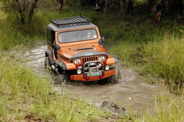 bej renkli jeep wrangler off-roader v8 geçiş çamurlu su birikintisi ezmek