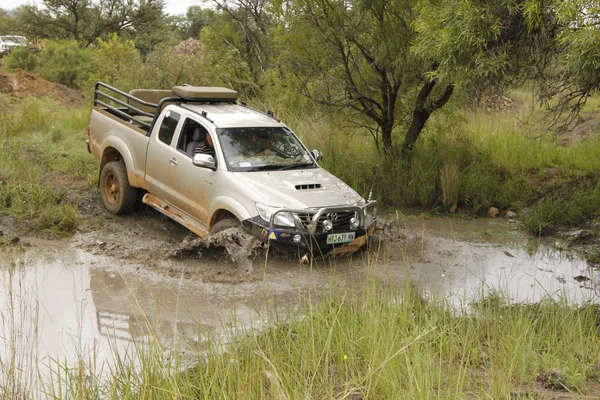 Beyaz Toyota raider hilux 3.0 l geçiş çamurlu su birikintisi — Stok fotoğraf