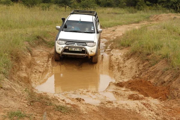 Blanco Toyota Triton DHD cruzar obstáculo de barro — Foto de Stock