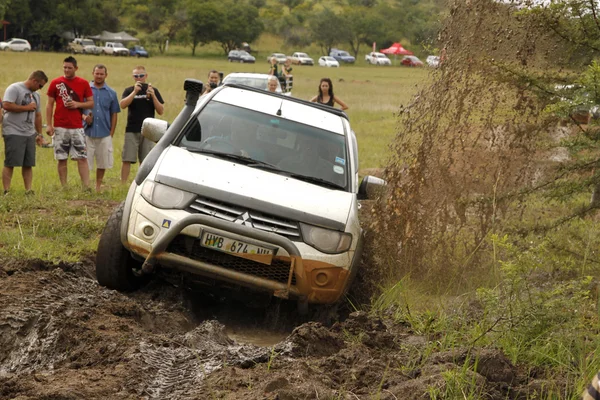 Biały toyota Tryton dhd przekraczania przeszkód błoto — Zdjęcie stockowe