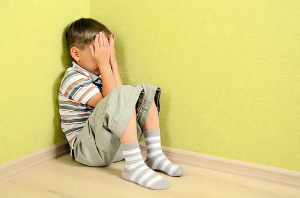 Menino criança parede canto punição sentado — Fotografia de Stock