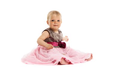 sevimli küçük bebek kız pembe elbiseli katta oturan