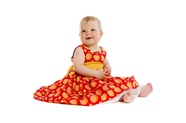 Adorável menina bebê em vestido vermelho sentado no chão — Fotografia de Stock